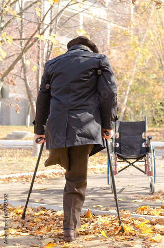 Photo: Handicapped one-legged man walking on crutches Handicapped one-legged man walking on crutches