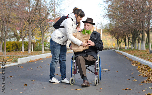Photo: Man in a wheelchair being helped with groceries Man in a wheelchair being helped with groceries