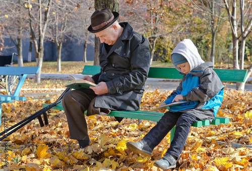 Photo: Young boy reading with his grandfather Young boy reading with his grandfather