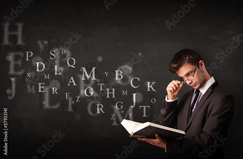 Photo: Young man reading a book with alphabet letters Young man reading a book with alphabet letters