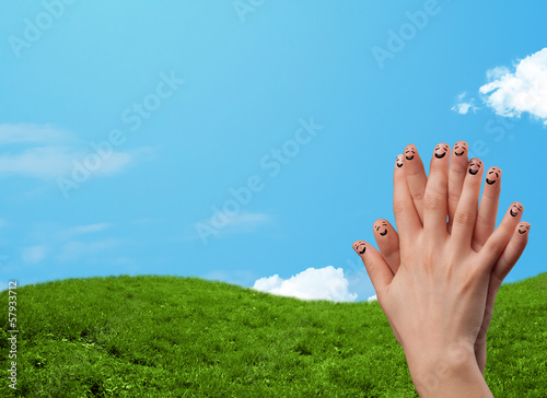 Photo: Cheerful finger smileys with landscape scenery at the background Cheerful finger smileys with landscape scenery at the background