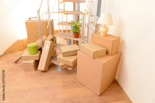 Photo: Stack of cartons near stairs: moving house concept Stack of cartons near stairs: moving house concept