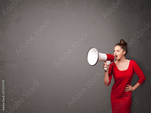 Photo: Girl shouting into megaphone on copy space background Girl shouting into megaphone on copy space background
