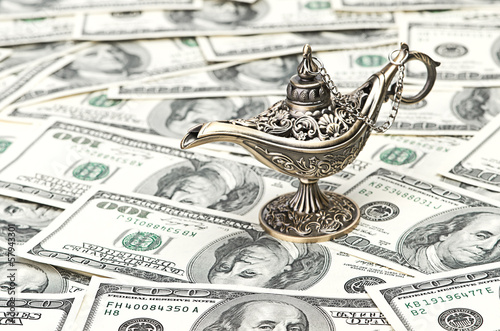 Photo: aladdin lamp on dollar background aladdin lamp on dollar background