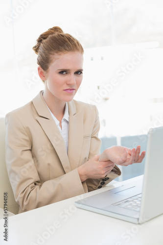 Photo: Businesswoman suffering from wrist pain in office Businesswoman suffering from wrist pain in office