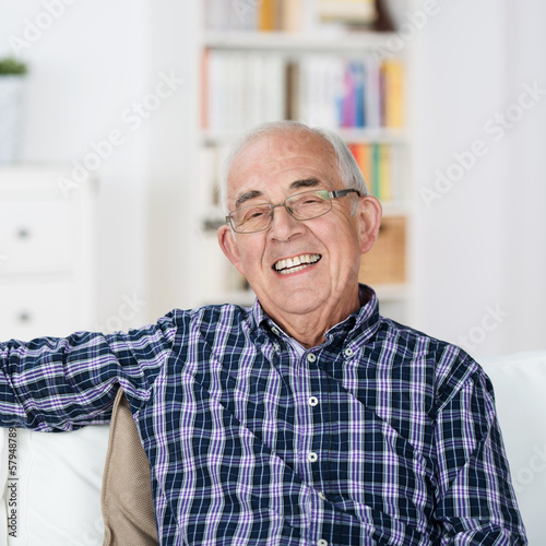 Photo: lächelnder senior sitzt entspannt zu hause lächelnder senior sitzt entspannt zu hause