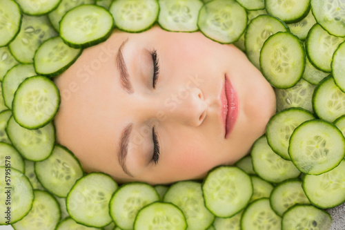 Photo: Beautiful woman with facial mask of cucumber slices on face Beautiful woman with facial mask of cucumber slices on face