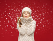 happy girl in winter clothes blowing on palms happy girl in winter clothes blowing on palms
