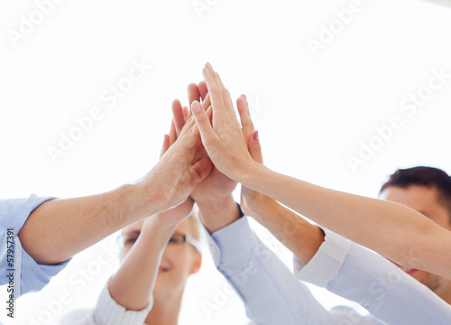 Photo: happy business team giving high five in office happy business team giving high five in office