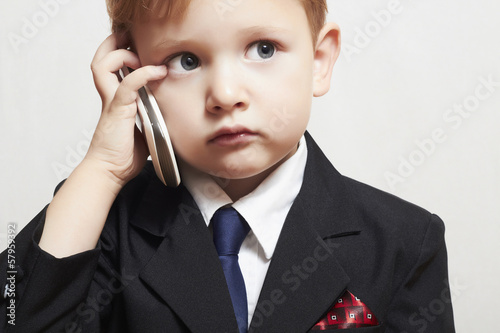 Photo: child in business suit with cell phone.fashionable little boy child in business suit with cell phone.fashionable little boy