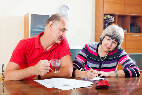 Photo: mature couple fills in questionnaire together mature couple fills in questionnaire together
