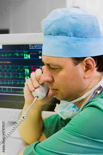 Photo: Young doctor with phone in ICU Young doctor with phone in ICU