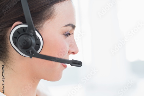 Photo: Close up side view of businesswoman wearing headset Close up side view of businesswoman wearing headset