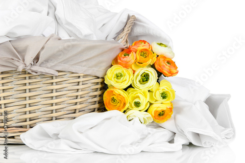 Photo: Rumpled bedding sheets in wicker basket isolated on white Rumpled bedding sheets in wicker basket isolated on white