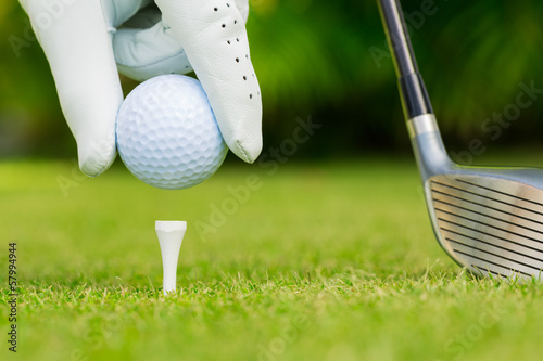 Photo: Close up view of golf ball on tee on golf course Close up view of golf ball on tee on golf course