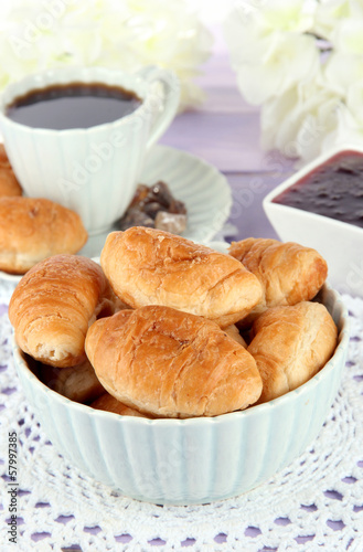 Photo: Tasty croissants and cup of coffee on table close-up Tasty croissants and cup of coffee on table close-up