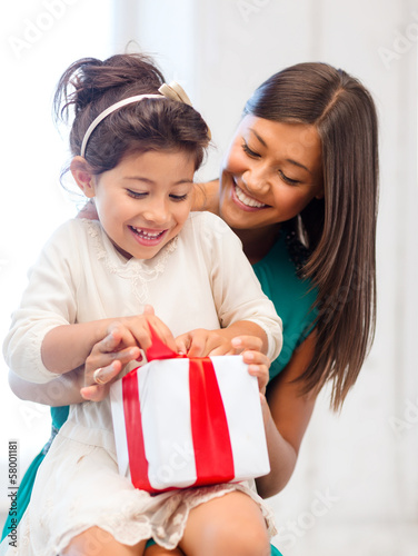 Photo: happy mother and child girl with gift box happy mother and child girl with gift box
