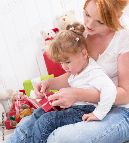 Photo: Mutter und Kind packen gemeinsam ein Geschenk aus Mutter und Kind packen gemeinsam ein Geschenk aus