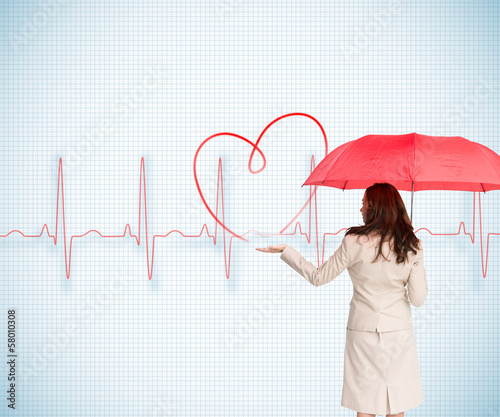 Photo: Composite image of businesswoman holding umbrella Composite image of businesswoman holding umbrella