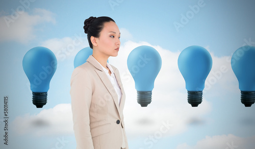 Photo: Composite image of unsmiling asian businesswoman Composite image of unsmiling asian businesswoman