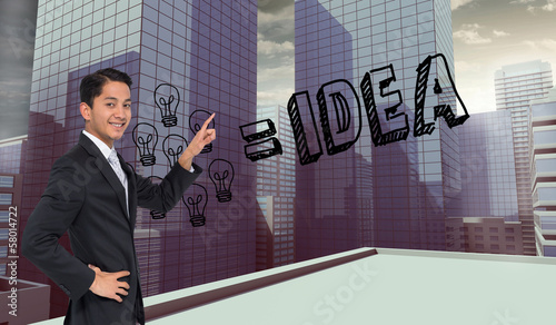 Photo: Composite image of smiling asian businessman pointing Composite image of smiling asian businessman pointing