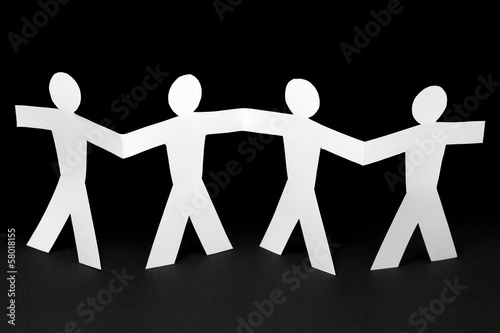 Photo: white paper people on black background white paper people on black background