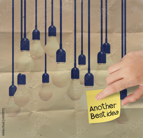 Photo: hand holding sticky note with another idea light bulb on crumple hand holding sticky note with another idea light bulb on crumple
