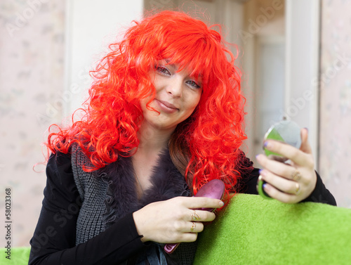 Photo: Woman in red wig with comb Woman in red wig with comb