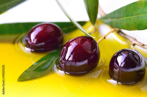 Photo: Olive oil and branch of olives closeup, background Olive oil and branch of olives closeup, background