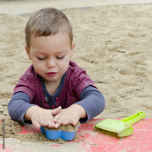 Photo: Child playing in sandpit Child playing in sandpit
