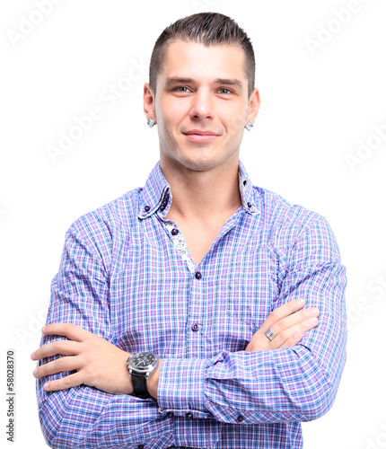 Photo: Casual young man looking at camera with arms crossed Casual young man looking at camera with arms crossed