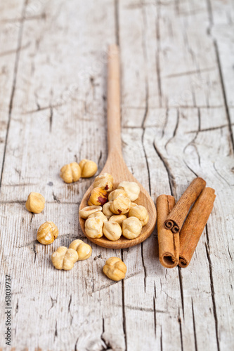 Photo: hazelnuts in wooden spoon and sinnamon sticks hazelnuts in wooden spoon and sinnamon sticks