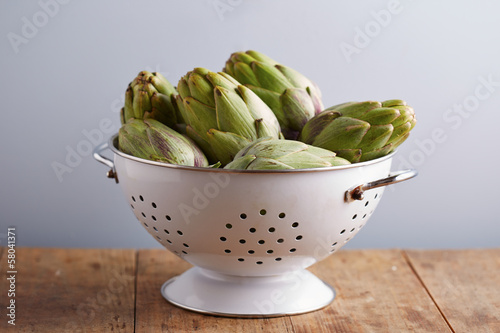 Photo: Raw pile of artichokes on colander Raw pile of artichokes on colander