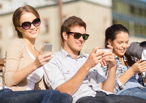 Photo: students looking at smartphones and tablet pc students looking at smartphones and tablet pc