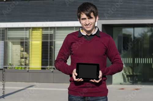 Photo: junger mann zeigt ein tablet junger mann zeigt ein tablet