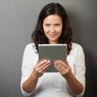 lächelnde frau schaut über tablet-pc lächelnde frau schaut über tablet-pc