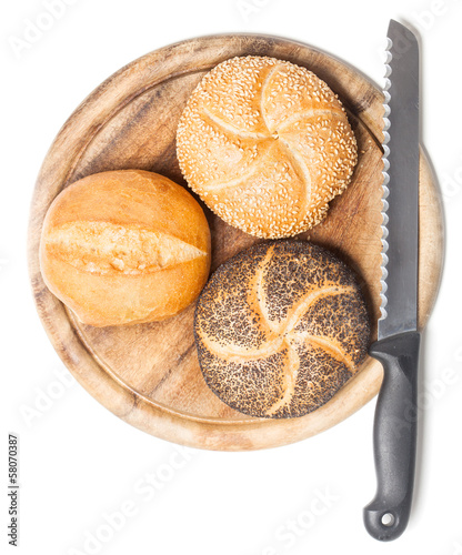 Photo: Different bread rolls on cutting board with knife Different bread rolls on cutting board with knife