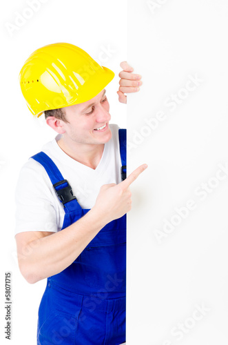 Photo: junger Bauarbeiter weist auf Werbetafel junger Bauarbeiter weist auf Werbetafel