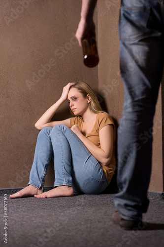 Photo: Despaired woman beaten by drunk man. Despaired woman beaten by drunk man.