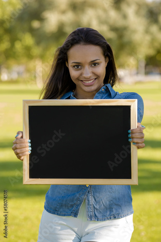 Photo: Beautiful woman holding a shalkboard Beautiful woman holding a shalkboard