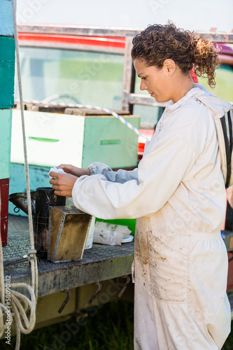 Photo: Beekeeper Fueling Smoker For Removing Honey Beekeeper Fueling Smoker For Removing Honey