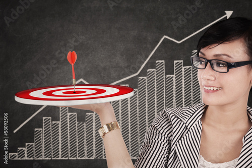 Photo: Businesswoman holding up a target Businesswoman holding up a target