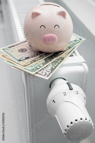 Photo: Heating thermostat with piggy bank and money Heating thermostat with piggy bank and money