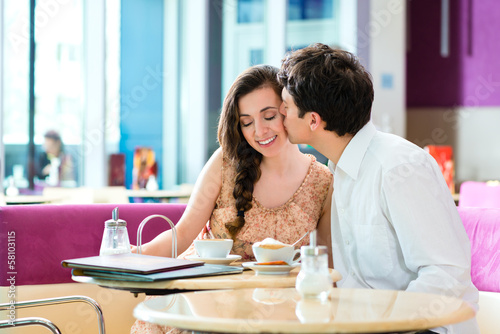 Photo: Young couple cafe hugging and kissing Young couple cafe hugging and kissing