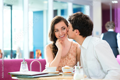 Photo: Young couple cafe hugging and kissing Young couple cafe hugging and kissing