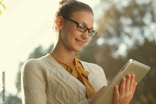 Photo: Closeup of young smart woman with tablet outdoors Closeup of young smart woman with tablet outdoors