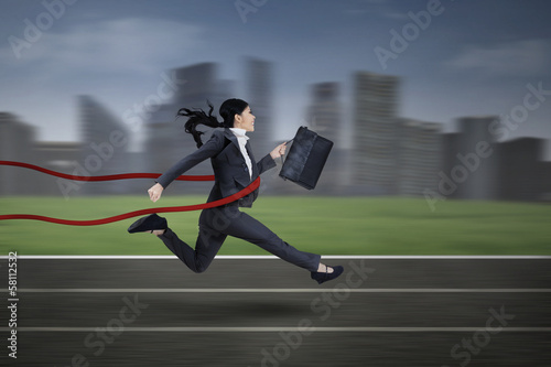 Photo: Asian businesswoman winning a race Asian businesswoman winning a race