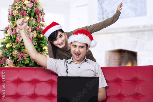 Photo: Christmas couple expressing success at home Christmas couple expressing success at home