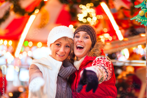 Photo: Freundinnen auf Weihnachtsmarkt in Adventszeit Freundinnen auf Weihnachtsmarkt in Adventszeit