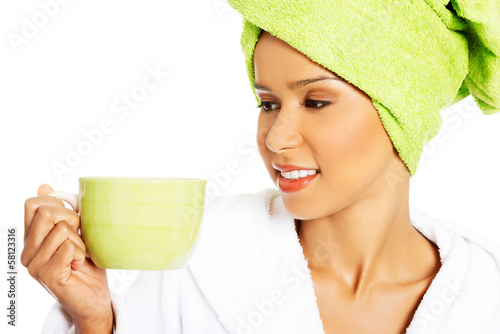 Photo: Attractive woman wrapped in towel with turban on head, holding a Attractive woman wrapped in towel with turban on head, holding a